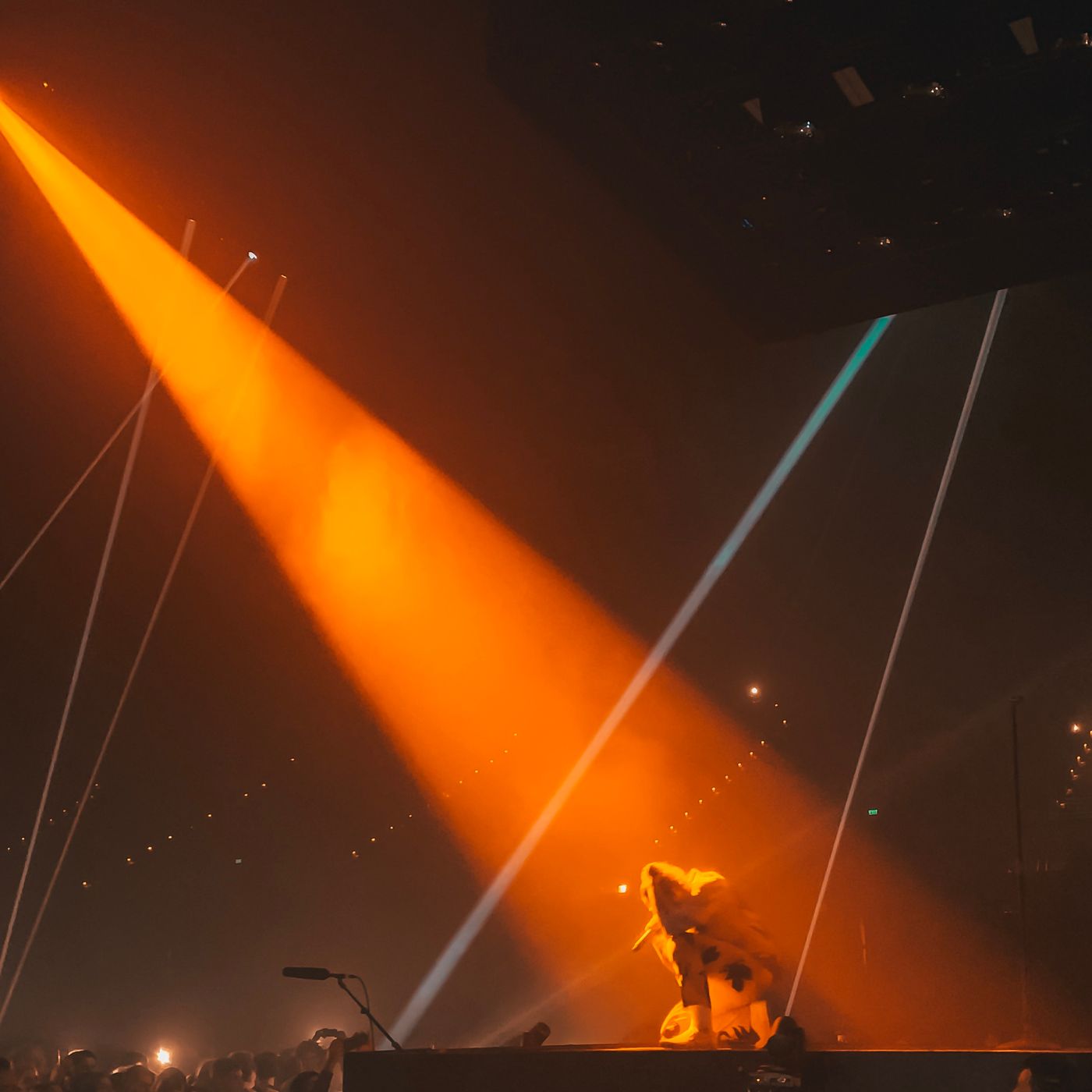 A live performer beneath a strong orange spotlight